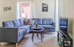 a living room with a blue couch and a table at Nice Home In Risr With Kitchen in Risør
