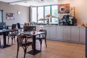 ein Restaurant mit Tischen und Stühlen und einer Küche in der Unterkunft Hobbit Hotel Mechelen in Mechelen