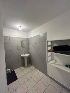 La salle de bains est pourvue d'un lavabo et de toilettes. dans l'établissement Appartement Le Tangor, à Saint-Leu