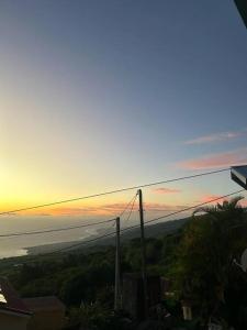 Cette maison offre une vue sur l'océan au coucher du soleil. dans l'établissement Appartement Le Tangor, à Saint-Leu