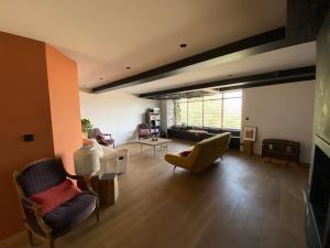 a living room with chairs and a couch and a table at Grande Maison d'architecte avec toit terrasse, Piscine sans vis à vis et Sauna 