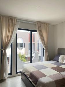 a bedroom with a bed and a large window at 2BR HOUSE Happystay at FREJA BSD lalerooms close to ICE BSD find us on ig lalerooms in Tangerang