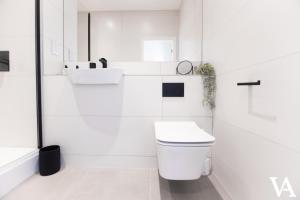 a white bathroom with a toilet and a sink at Velvet Apartments - 56 Vicar Lane in Leeds