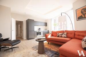 a living room with an orange couch and a table at Velvet Apartments - 56 Vicar Lane in Leeds