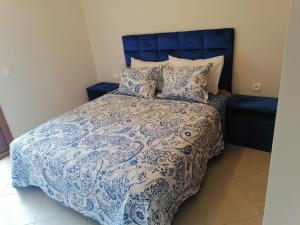 1 cama con edredón y almohadas azules y blancos en Lilac's Garden vue piscine en M'diq