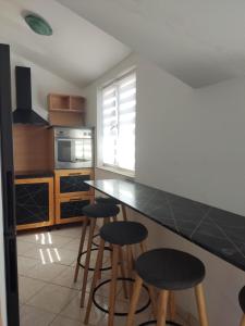 una cocina con encimera negra y taburetes en Apartments Villa Dalmatina, en Vodice