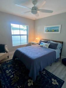Schlafzimmer mit einem blauen Bett und einem Deckenventilator in der Unterkunft House on Hibiscus: #SiestaBeach in Sarasota