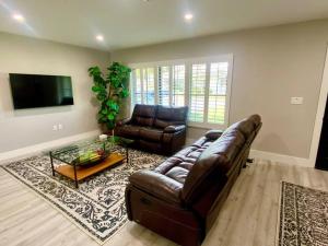 ein Wohnzimmer mit einem Ledersofa und einem Tisch in der Unterkunft House on Hibiscus: #SiestaBeach in Sarasota