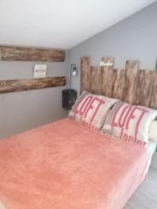 - une chambre avec un lit et une tête de lit en bois dans l'établissement Chambre 23m2 avec jardin Wi-Fi gratuit Saint-Girons, à Saint-Girons