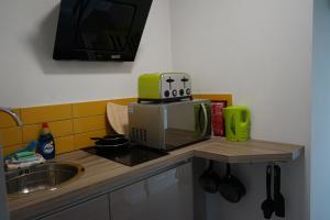 a kitchen counter with a microwave and a sink at Lincoln Self Catering in Lincoln