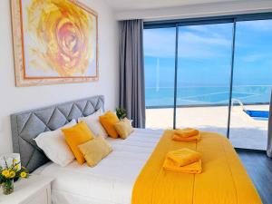 Un dormitorio con una cama con almohadas amarillas y una ventana. en Villa Céu e Mar, en Prazeres 45 fotos más