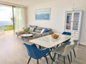 Una sala de estar con una mesa y sillas y un sofá. en Villa Céu e Mar, en Prazeres