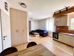 uma cozinha e sala de estar com uma mesa e um sofá em BS Apartman em Podgorica