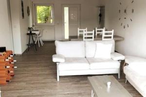 a living room with a white couch and a table at Ferienwohnung zur dicken Berta in Wolfegg