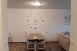 a dining room with a table and a clock on the wall at Ferienwohnung zur dicken Berta in Wolfegg