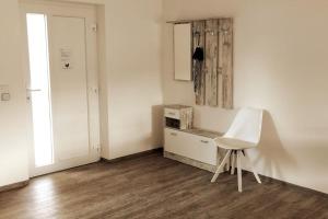a room with a white chair and a cabinet at Ferienwohnung zur dicken Berta in Wolfegg