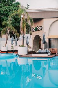 a hotel with a swimming pool in front of a building at Bamboo Suites Hotel in Ialysos