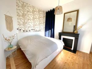um quarto com uma cama branca e uma lareira em The Jungle Flat em Rouen