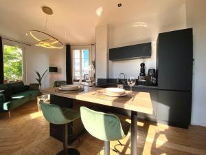 uma cozinha e sala de estar com mesa e cadeiras em The Jungle Flat em Rouen