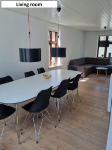 ein Wohnzimmer mit einem großen weißen Tisch und Stühlen in der Unterkunft Tæt på Centrum & MCH/Boxen - Huset nr. 11 in Herning