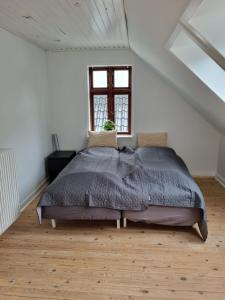 ein Schlafzimmer mit einem großen Bett in einem weißen Zimmer in der Unterkunft Tæt på Centrum & MCH/Boxen - Huset nr. 11 in Herning