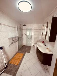 a white bathroom with a sink and a shower at Villa 12 in Ketzin