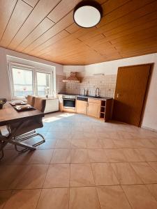 eine große Küche mit einer Holzdecke und einem Tisch in der Unterkunft Villa 12 in Ketzin