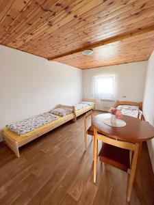 a room with two beds and a table in it at Penzion Hevera in Kuchařovice