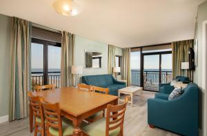 sala de estar con mesa, sillas y sofá en Grande Shores Ocean Resorts Condominiums, en Myrtle Beach