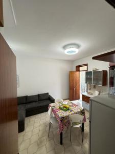 a living room with a table and a kitchen at Casa del Sol in Torre Forte