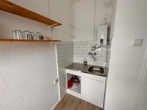 eine kleine Küche mit Spüle und Waschmaschine in der Unterkunft Apartment City und Stadionnah I Privatparkplatz inklusive I in Dortmund