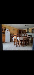 a kitchen with a table and chairs and a refrigerator at Maison de campagne in Gourin