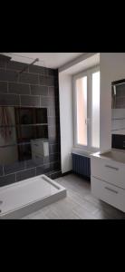 a bathroom with a white tub and a window at Maison de campagne in Gourin