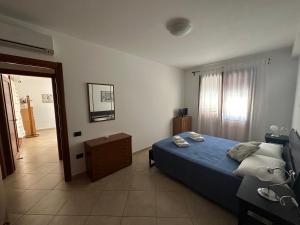 a bedroom with a blue bed and a mirror at Profumo di mare in Càbras