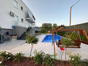 a house with a swimming pool with a swing at Summer Residence Una in Bihać