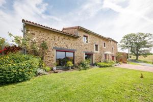 an external view of a stone house with a yard at LE CLOS DU MOUY in La Souche