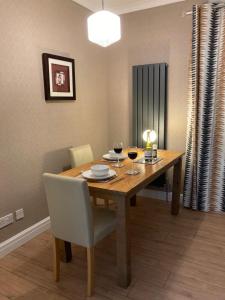 a dining room table with two glasses of wine at Quiet flat with parking in Cleveleys