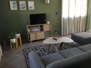 a living room with a couch and a tv at Casa Verde 2 in Godoy Cruz