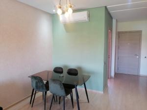 a dining room table and chairs in a room at Appartement prestigia jade marrakech in Marrakesh