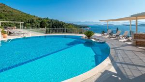 a large swimming pool with a view of the ocean at Kalami Beach - Villa Kouloura in Kalami