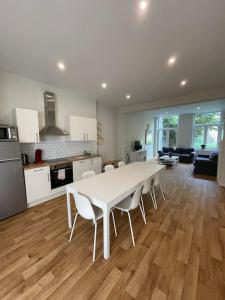 eine Küche und ein Wohnzimmer mit einem weißen Tisch und Stühlen in der Unterkunft Maison 4 chambres avec jardin in Lüttich