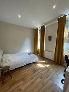 1 dormitorio con 1 cama y suelo de madera en Maison 4 chambres avec jardin, en Lieja