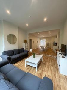 a living room with a blue couch and a table at Maison 4 chambres avec jardin in Liège