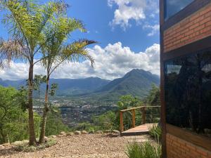 a house with a palm tree and mountains in the background at Chale Herrmann Haus berghaus in Corupá