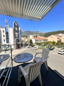 a balcony with two chairs and a table and a street at Vila Centar in Budva