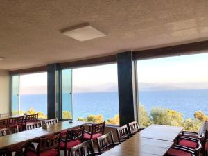 Yakabük Otel & Restaurant في موغلا: مطعم به طاولات وكراسي ومطل على المحيط