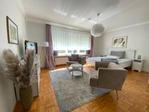 un soggiorno con letto e divano di Erholsames Wohnen in Bad Bramstedt Appartement III a Bad Bramstedt
