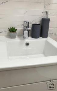 a bathroom sink with two cups and a faucet at Lindy Home in Burgas