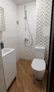 a white bathroom with a toilet and a shower at Lindy Home in Burgas