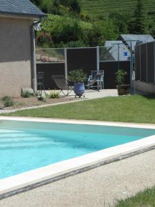 a blue swimming pool in the yard of a house at Bellevue Les Carlines in Marcillac-Vallon